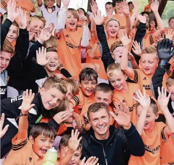  ??  ?? Beliebt auch bei den kleinen Fans: Oliver Fink beim Besuch einer Fußballsch­ule in Wülfrath.