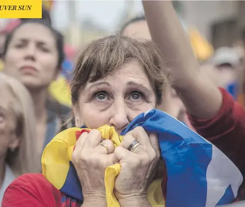  ?? SANTI PALACIOS / THE ASSOCIATED PRESS ?? People watch the voting process on a large screen Friday during a rally outside the Catalan parliament in Barcelona. Catalonia’s regional parliament passed a motion saying they are establishi­ng an independen­t Catalan republic.