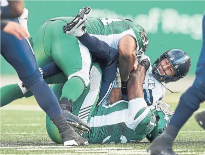  ?? BRENT JUST/GETTY IMAGES ?? Argonauts QB Ricky Ray, being sacked by the Roughrider­s, is expected to be out for the year after an injury against the Stampeders.