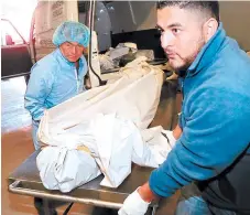  ?? FOTO: ESTALIN IRÍAS ?? Momentos en que ingresan a la morgue el cadáver de Cárdenas.