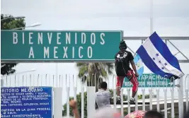  ?? JOHAN ORDONEZ / AFP / GETTY IMAGES ?? A Honduran migrant climbs the gate of the Guatemala-Mexico internatio­nal border bridge in Ciudad Tecun Uman on Friday.