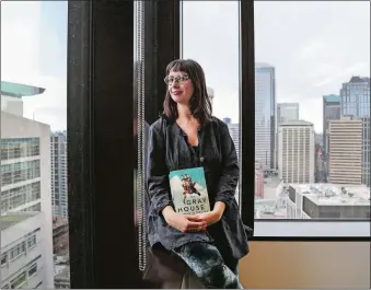  ?? JOHNNY ANDREWS/SEATTLE TIMES/TNS ?? Gabriella Page-Fort, the editorial director for AmazonCros­sing, poses for a portrait on Wednesday, March 8, 2017, in Seattle, while holding a copy of the book “The Gray House” by Mariam Petrosyan.