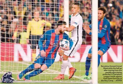  ??  ?? Barcelona forward Lionel Messi picks the ball up after scoring from the penalty spot during yesterday’s Champions League match against Paris Saint-Germain at the Nou Camp. – AFPPIX