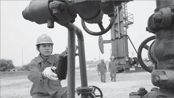  ?? HU QINGMING / FOR CHINA DAILY ?? An employee checks crude oil processing equipment at the Shengli Oil Field in Dongying, Shandong province.