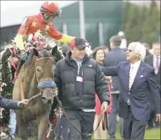  ?? David J. Phillip/Associated Press ?? Mike Smith celebrates with trainer Bob Baffert, far right, after riding Abel Tasman to victory in the 143rd running of the Kentucky Oaks horse race Friday in Louisville, Ky.