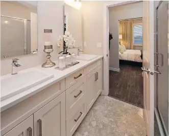  ??  ?? The attractive master ensuite features dual vanities and a shower with tile.