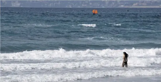  ?? Fotos: dpa ?? Eine Frau geht am Strand von Arenal zum Schwimmen in die Wellen.