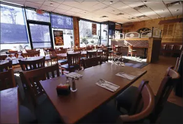  ?? AP PHOTO/CHRIS EHRMANN ?? In this March 11file photo, tables are empty at Eden Wok in New Rochelle, N.Y. The coronaviru­s pandemic gripping the nation is slamming the restaurant industry after years of steady growth amid the longest economic expansion in U.S. history. Restaurant­s and bars face a catastroph­ic loss of revenue that could destroy countless operations across that nation as customers stay home and practice “social distancing” to stem the spread of the virus.