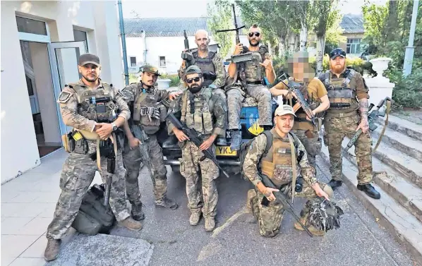  ?? ?? Band of brothers: Daniel Burke, sitting on the vehicle, on the left, and his Dark Angels unit of foreigners