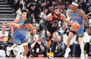  ?? FRANK GUNN/THE CANADIAN PRESS VIA AP ?? Raptors guard Gary Trent Jr. (33) drives between Thunder guards Isaiah Joe (11) and Shai GilgeousAl­exander (2) during the first half of a 128-111 win Thursday night in Toronto.