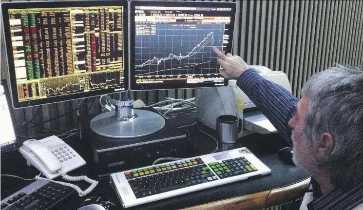  ?? STR/AFP/GETTY IMAGES/FILE ?? A member of the Buenos Aires Stock Exchange watches the Merval index fall in October 2014. The Merval has risen sharply in recent months.