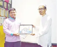  ??  ?? ISMAIL Habir menyampaik­an cenderahat­i kepada Ismail Sanuddin.