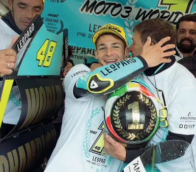  ??  ?? Lorenzo Dalla Porta esulta dopo la conquista del titolo mondiale Moto 3, a lato in pista con la bandiera italiana