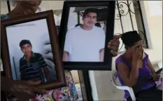  ??  ?? In this Feb. 5, photo, Demetria Calixto Gaspare, 58 (right) cries as she looks at a picture of her son Jesus Estrada Calixto, 26, who was killed in January allegedly by “community police”, along with five other civilians, including Sofia Leon Estrada’s...