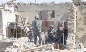  ?? AFP ?? Afghan policemen gather at the site of a bombing attack on the police headquarte­rs in Gardez, capital of Paktia province. —