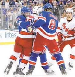  ?? GETTY ?? Rangers Ryan Lindgren (l.) and Jacob Trouba mix it up with Carolina’s Max Domi after final horn of Game 3 at the Garden.