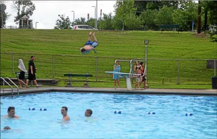  ?? NICHOLAS BUONANNO -MEDIANEWS GROUP FILE ?? Christophe­r Natale jumps off the diving board at Lansing’s Pool on opening day in 2017. Lansing Pool will open July 5.