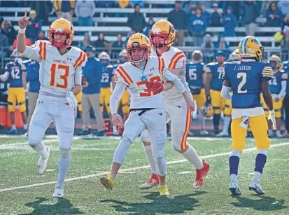  ?? KENNETH K. LAM PHOTOS/BALTIMORE SUN ?? Calvert Hall kicker Dylan Manna, center, celebrates his 30-yard game-winning field goal with teammates Dane Grunder, left, and Patrick O’Keefe in the fourth quarter.