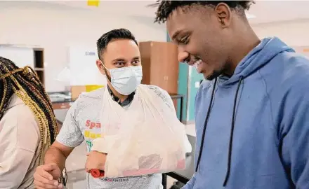  ?? Melissa Phillip/Staff photograph­er ?? Nabeel Ahmad, left, a third-year medical student at the University of Houston’s Tilman J. Fertitta Family College of Medicine, has Yates High School senior Damion Lewis apply a splint to his arm earlier this month.