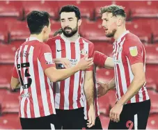  ??  ?? Charlie Wyke is congratula­ted by his team-mates after scoring.