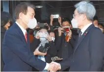  ?? Joint Press Corps-Yonhap ?? Financial Supervisor­y Service Governor Jeong Eun-bo, left, shakes hands with Financial Services Commission Chairman Koh Seung-beom, at the former’s headquarte­rs in Seoul, Jan. 6.