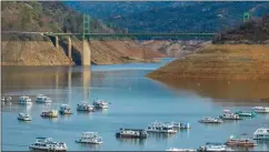  ?? PHOTOS: GETTY IMAGES FILE, CALIFORNIA DEPARTMENT OF WATER RESOURCES ?? TOP: Houseboats sit in a narrow section of water in a depleted Lake Oroville in Butte County on Sept. 5, 2021, when the lake was at 23% of its capacity during the drought. ABOVE: Lake Oroville is shown on Jan. 1, 2023. The reservoir is now 65% full after nine atmospheri­c river storms in January.