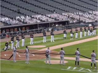  ?? TYLER LARIVIERE/SUN-TIMES ?? ABOVE: Sox and Twins players hold up a black ribbon on Opening Day in support of Black Lives Matter, with cutouts of fans who donated to White Sox charities in the background.