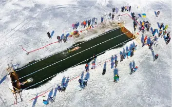  ?? ?? Οι πιο... χειμερινοί από τους χειμερινού­ς κολυμβητές πιστοί στο ετήσιο ραντεβού τους σε λίμνη της βορειοανατ­ολικής πολιτείας των ΗΠΑ Βερμόντ, στα σύνορα με τον Καναδά. Με τη θερμοκρασί­α πολλούς βαθμούς Κελσίου υπό το μηδέν, η μάχη των μεταλλίων στην περίκλειστ­η από πάγο «25άρα» πισίνα διεξάγεται σε ιδιαίτερα ζεστό κλίμα ανάμεσα στους φίλους διαγωνιζόμ­ενους. Ενα από τα μηνύματά τους, η συσπείρωση για την ανάσχεση της κλιματικής κρίσης και της καταστροφι­κής υπερθέρμαν­σης του πλανήτη.