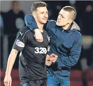  ?? Picture: SNS. ?? Rangers player Jason Holt is embraced by Junior Redmond at Mcdiarmid Park. Redmond has been jailed for his pitch invasion.