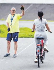 ?? FOTO: UWE ANSPACH/DPA ?? Bremsen bitte! Conny Heinz Kraft (links) bietet Radfahrkur­se für Erwachsene an. Die Nachfrage ist groß.
