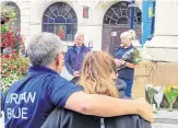  ??  ?? Volunteers look on as Rev Arthur Houston, left, and Val Jacobs speak at the remembranc­e event