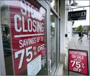  ?? STEVEN SENNE — THE ASSOCIATED PRESS ?? Passers-by walk past a business storefront with store closing and sale signs in Dedham, Mass.