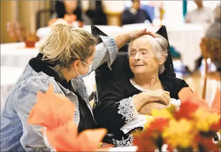  ?? Carolyn Cole Los Angeles Times ?? RUZANNA GRIGORYAN of Chatsworth, left, visits grandmothe­r Anahit Papiryan at a Mission Hills nursing facility on Thanksgivi­ng Day. Under a state order, visitors to nursing homes and care facilities must provide a negative result from a PCR or an antigen test.