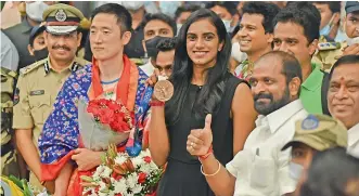  ?? R. PAVAN ?? P. V. Sindhu shows off her bronze medal upon arrival at the Hyderabad airport on Wednesday.
—