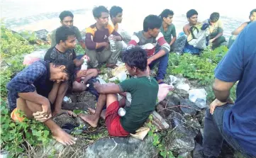  ?? — Reuters photo ?? Dozens of people, believed to be Rohingya Muslims from Myanmar who were dropped off from a boat are pictured on a beach near Sungai Belati, Perlis in this undated handout photo.