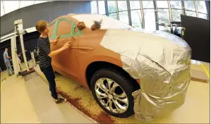  ?? AP PHOTO/JOSE JUAREZ ?? General Motors creative clay sculptor Gianna Ball smoothes loose clay on a model of a 2018 Buick Enclave frame Aug. 25, 2017 at the GM Tech Center in Warren, Mich.