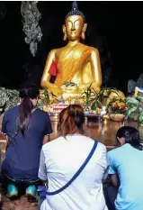  ??  ?? Vigil: Relatives pray to Buddha statue