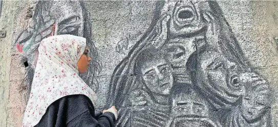  ?? [Privat] ?? Menna Hamouda vor einem ihrer Graffiti im Gazastreif­en. Vor dem Krieg malte sie mit bunten Farben.