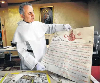  ?? SAFIN HAMED/AFP ?? Salvador. Padre Michael Najeeb exibe um manuscrito do século 16, parte das centenas de documentos que resgatou