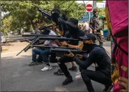  ?? (AP) ?? Protesters form a line while armed with homemade air rifles Saturday during a demonstrat­ion against the military coup in Rangoon, Burma.