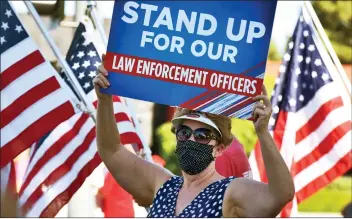  ?? Dan Watson/The Signal ?? (Above) Mary Terry, of Canyon Country, joins hundreds of demonstrat­ors at a Blue Lives Matter rally at Magic Mountain Parkway and Valencia Boulevard on Friday. (Right) Event organizer Steven Baron invites passing cars to “Honk your horn to support police.”