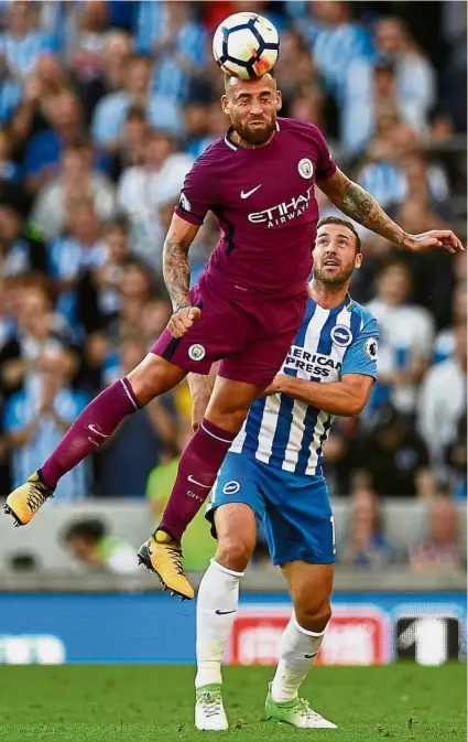  ?? — Reuters ?? A defender rises: Manchester City’s Nicolas Otamendi heading the ball in front of Brighton’s Glenn Murray in the English Premier League match on Aug 12. City won 2- 0.