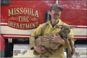  ?? NATE SINK VIA AP ?? Nate Sink cradles a newborn elk calf that he encountere­d in a remote, fire-scarred area of the Sangre de Cristo Mountains near Mora, N.M., on Saturday.