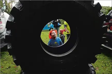  ?? DANA JENSEN/THE DAY ?? Tyler Daniels, 4, of Groton takes a close look at a tire that is 5 feet, 6 inches in diameter and weighs 1,200 pounds, on display Saturday during the 11th annual Touch-a-Truck event at McCook Point Park in Niantic. The event was co-sponsored by the East Lyme Auxiliary of Child and Family Agency of Southeaste­rn Connecticu­t and the East Lyme Parks and Recreation Department.