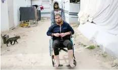  ??  ?? KHAN YUNIS, Palestinia­n Territorie­s: Samir Al-Najjar sits on a wheelchair next to his prefabrica­ted metal home in the southern Gaza Strip town. — AFP