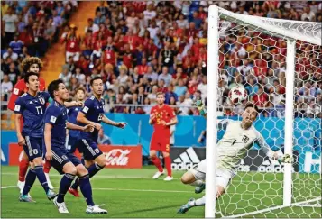  ?? REBECCA BLACKWELL / THE ASSOCIATED PRESS ?? Japan goalkeeper Eiji Kawashima (right) fails to save a ball as Belgium’s Jan Vertonghen (center) scores his first side’s goal during the round of 16 match between Belgium and Japan, Monday in the Rostov Arena, in Rostov-on-Don, Russia.