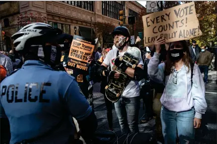  ?? Picture: Chris Mcgrath/getty ?? A police officer stands in front of a protest in support of counting all votes in Philadelph­ia, Pennsylvan­ia