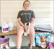  ?? Submitted Photo ?? Ember Crawley, a member of the Gravette Gleamers 4-H, poses with pet food, blankets and other pet supplies she and her fellow club members collected for donation to the Bella Vista Animal Shelter. Donations were also made to animal shelters at Gravette and Centerton.