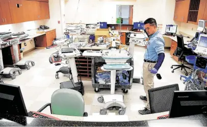  ?? Elizabeth Conley / Staff photograph­er ?? Danny Chang, a Houston Methodist tech analyst, sets up computers on wheels for a special wing at the hospital’s Katy campus.