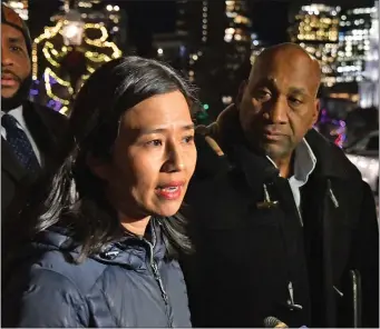  ?? CHRIS CHRISTO — BOSTON HERALD ?? Mayor Michelle Wu speaks with the media at the door to the Parkman House on Beacon Street as state Rep. Russell Holmes looks on just before the Dec. 13 party for “electeds of color.”